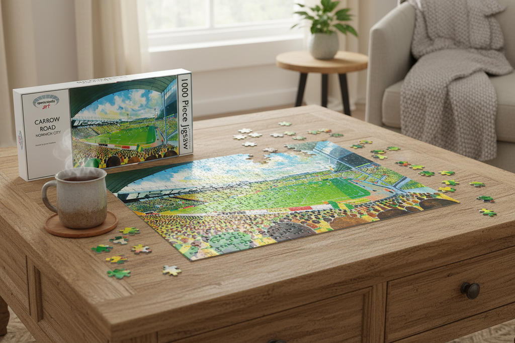 Carrow Road Norwich City 1000 piece jigsaw puzzle partially assembled on a table with box and mug of tea